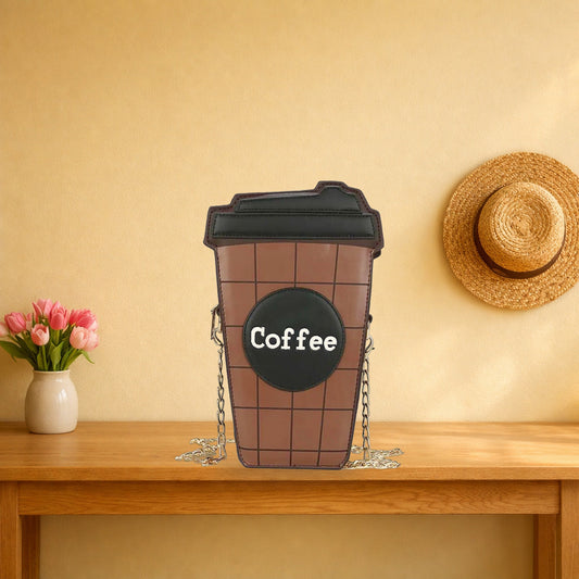 Brown coffee cup crossbody bag with a black lid on an oak hall table