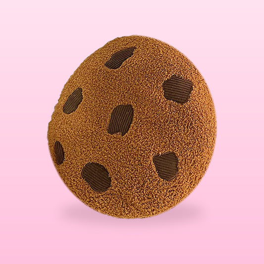 Brown choc chip cookie plush cushion, on a pastel pink background