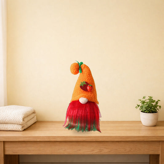 Strawberry plush gnome with an orange hat on a light oak console table