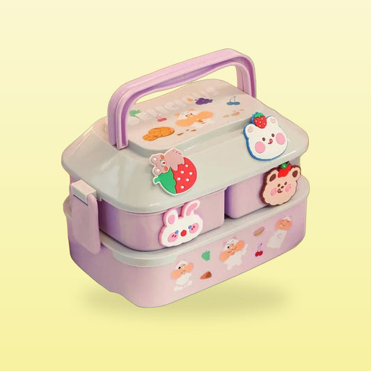 Purple two tier bento lunch box with bunny and strawberry stickers and a carry handle, on a butter yellow background
