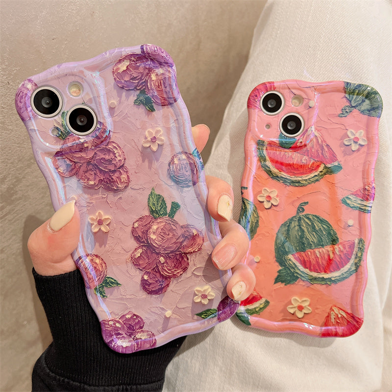 Two textured phone cases: lavender with purple flowers and white blooms; coral-pink with watermelon slices.