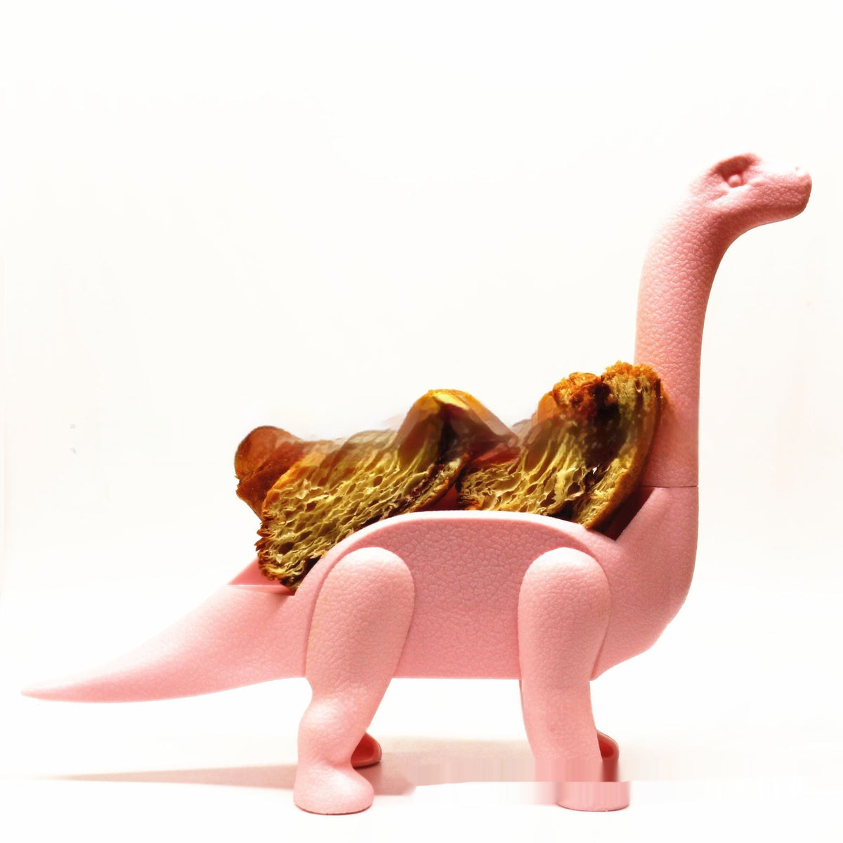 Pink dino taco holder carrying pastries on its back