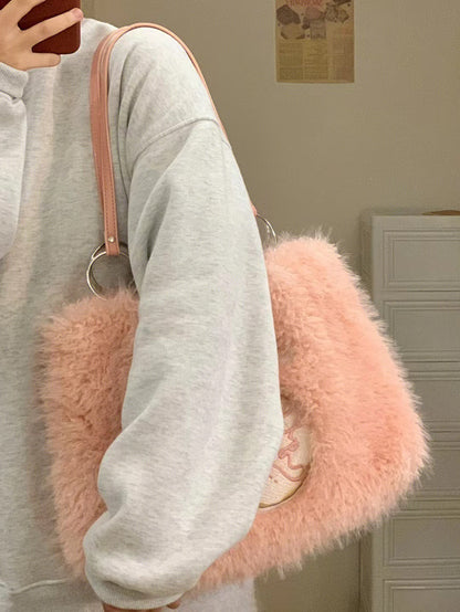 Pink plush tote bag with fluffy texture, features donut embroidery, double metal rings, and soft pink straps.