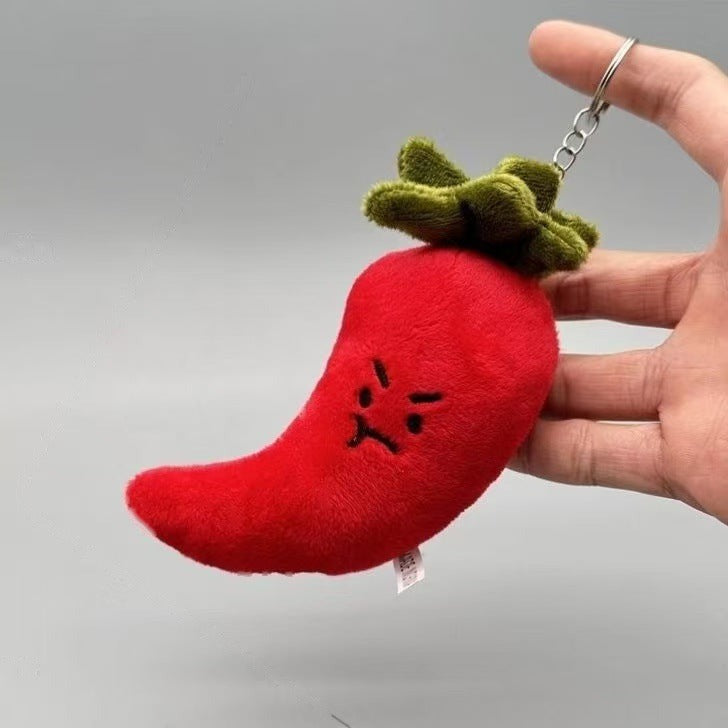 Grumpy red chilli plush keychain held in a hand