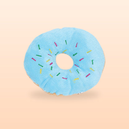 Blue plush donut squeaky pet toy with embroidered sprinkles, on a soft peach background