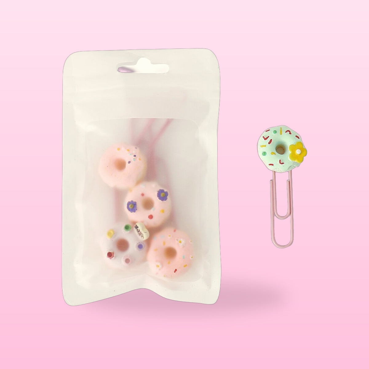 Donut paper clips in a clear resealable pack with one mint donut clip beside it, on a pink background