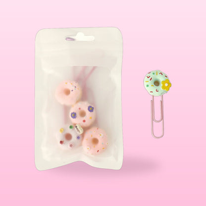 Donut paper clips in a clear resealable pack with one mint donut clip beside it, on a pink background