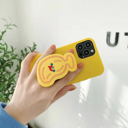 Hand holding yellow iPhone case with attached yellow fruit-shaped grip decorated with red and blue dots.