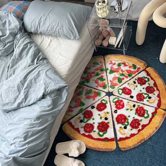 6 pizza-slice tufted rug pieces arranged into a round pepperoni and veggie pizza on blue carpet beside bed.