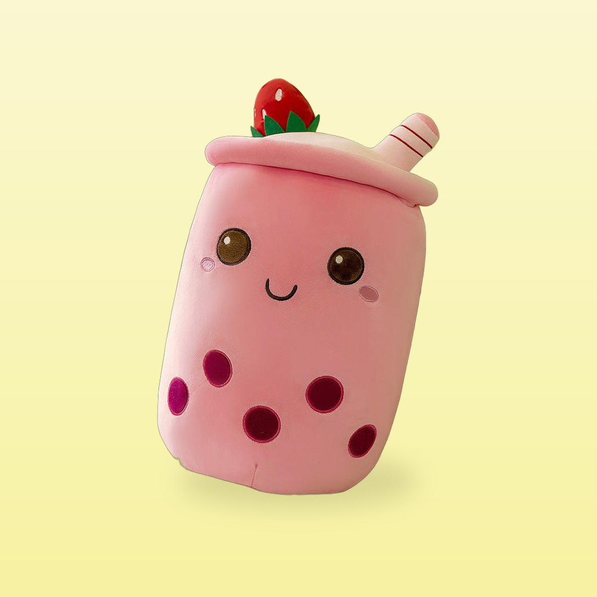 Strawberry milk tea plush pillow, pink cup with a strawberry on the lid, on a butter yellow background