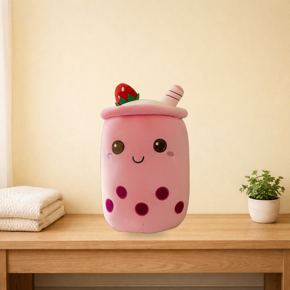 Strawberry milk tea plush pillow sitting on a light oak bench