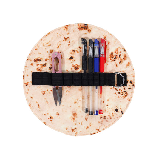 Burrito pencil case opened flat with pens and snips in the elastic strap