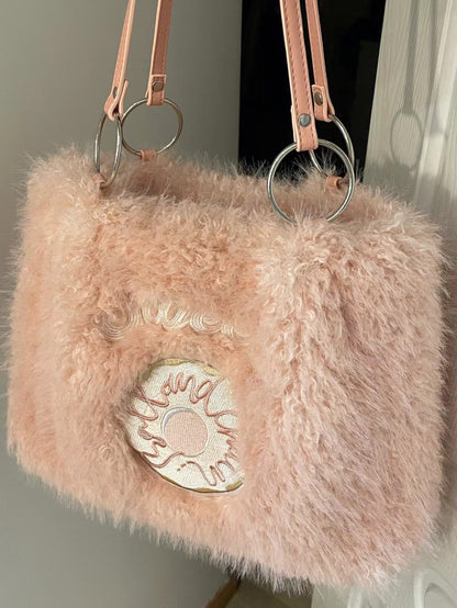 Pink plush tote bag with a fluffy texture, featuring a donut embroidery on the front and silver ring handles.