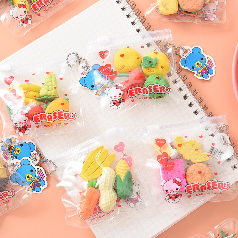 Six clear zip pouches holding colorful food-shaped erasers (banana, corn, peanut, cookie) and cartoon tags.