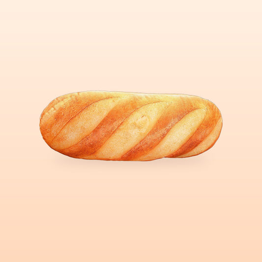 French bread plush pillow lying flat, on a soft peach background