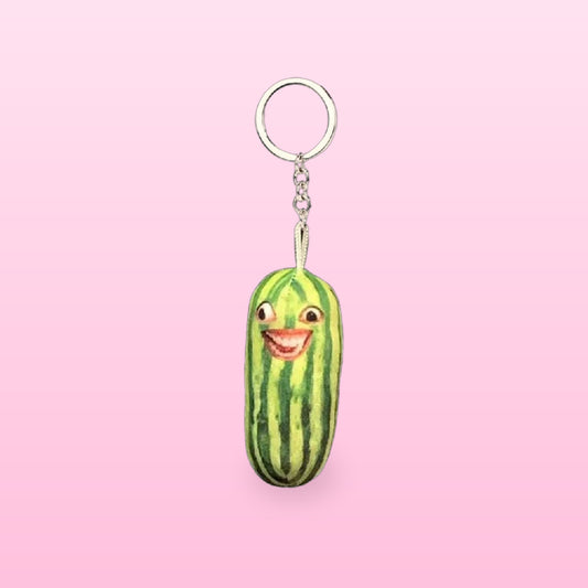 Grinning watermelon plush keychain with a silver keyring and chain, on a pink background
