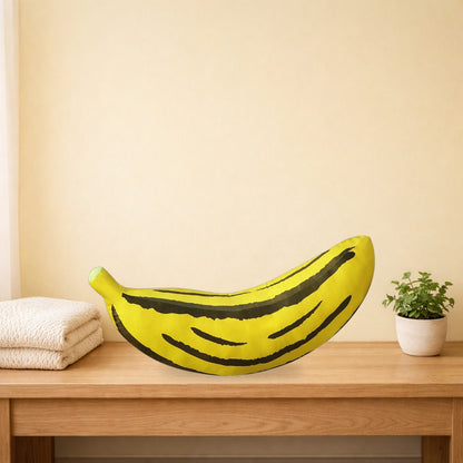 Giant banana plush cushion lying along a light oak bench