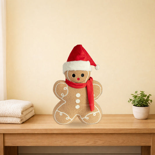 Gingerbread cookie cushion in a Santa hat standing on a light oak console table