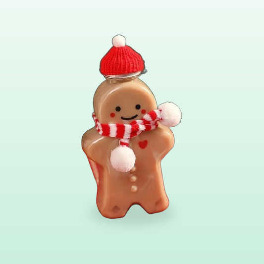 Gingerbread man juice bottle with a red knitted hat and striped scarf, filled with milk tea, on a soft mint background