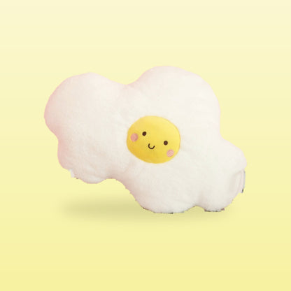 Fried egg plush cushion with a smiling yolk, on a butter yellow background