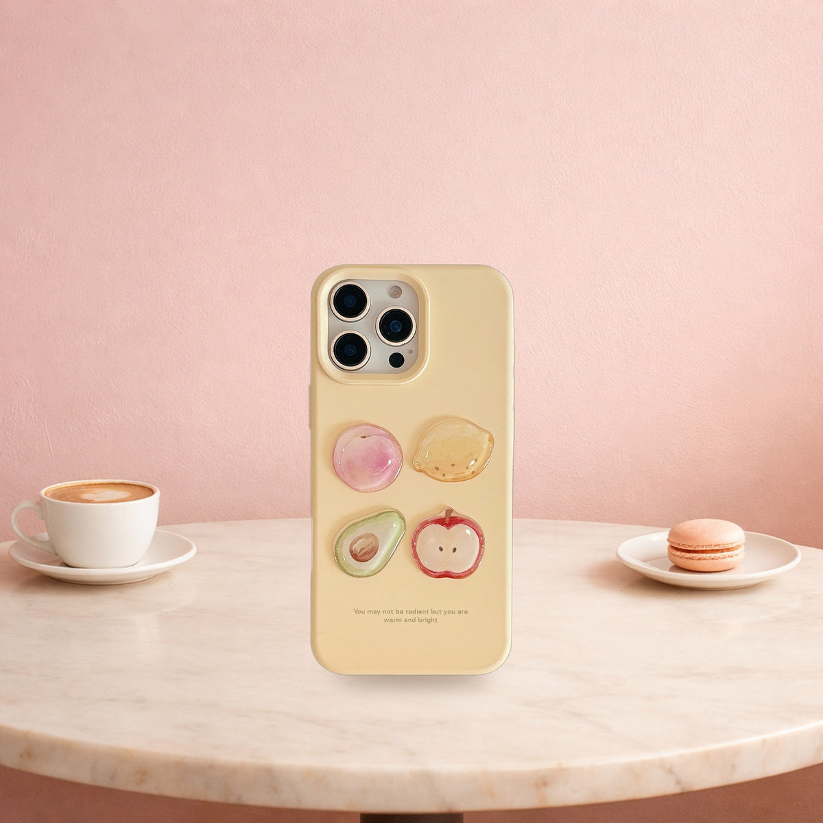 Cream yellow 3D fruit iPhone case standing on a pink cafe table