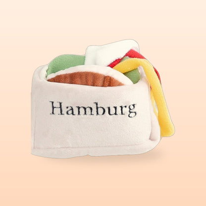 Burger snuffle pet toy with plush fillings tucked in its bun, on a peach background