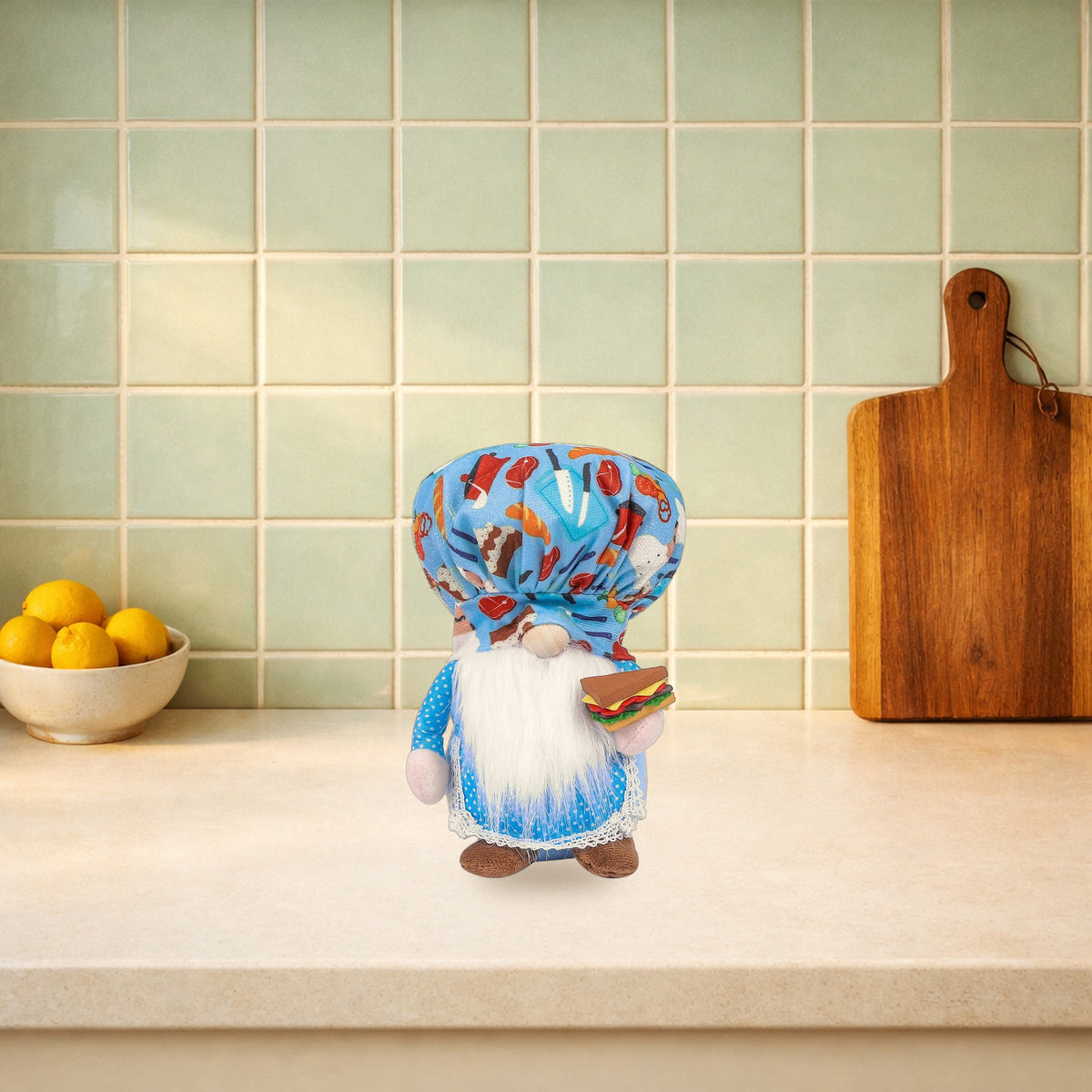 Blue chef gnome plush doll holding a sandwich on a kitchen worktop