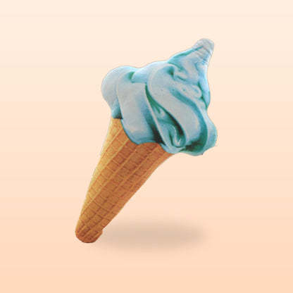 Blue ice cream cone plush pillow with a swirled top and waffle cone, on a soft peach background