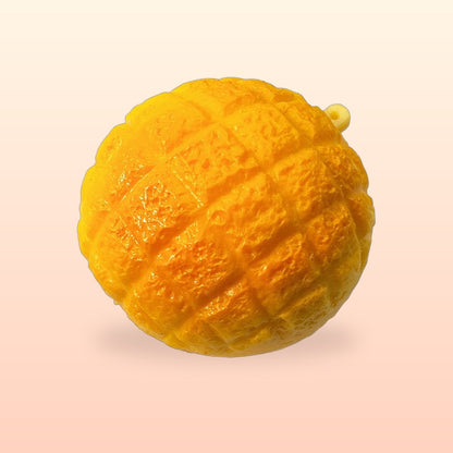 Golden Original pineapple bun squishy with a small hanging loop on a peach background