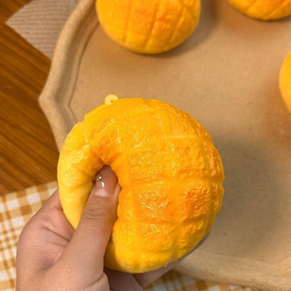 Pineapple bun squishy squeezed in one hand to show its palm size and slow rebound