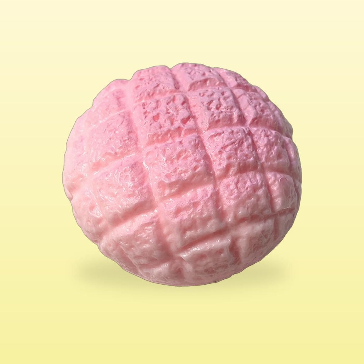 Strawberry Pink pineapple bun squishy on a butter yellow background
