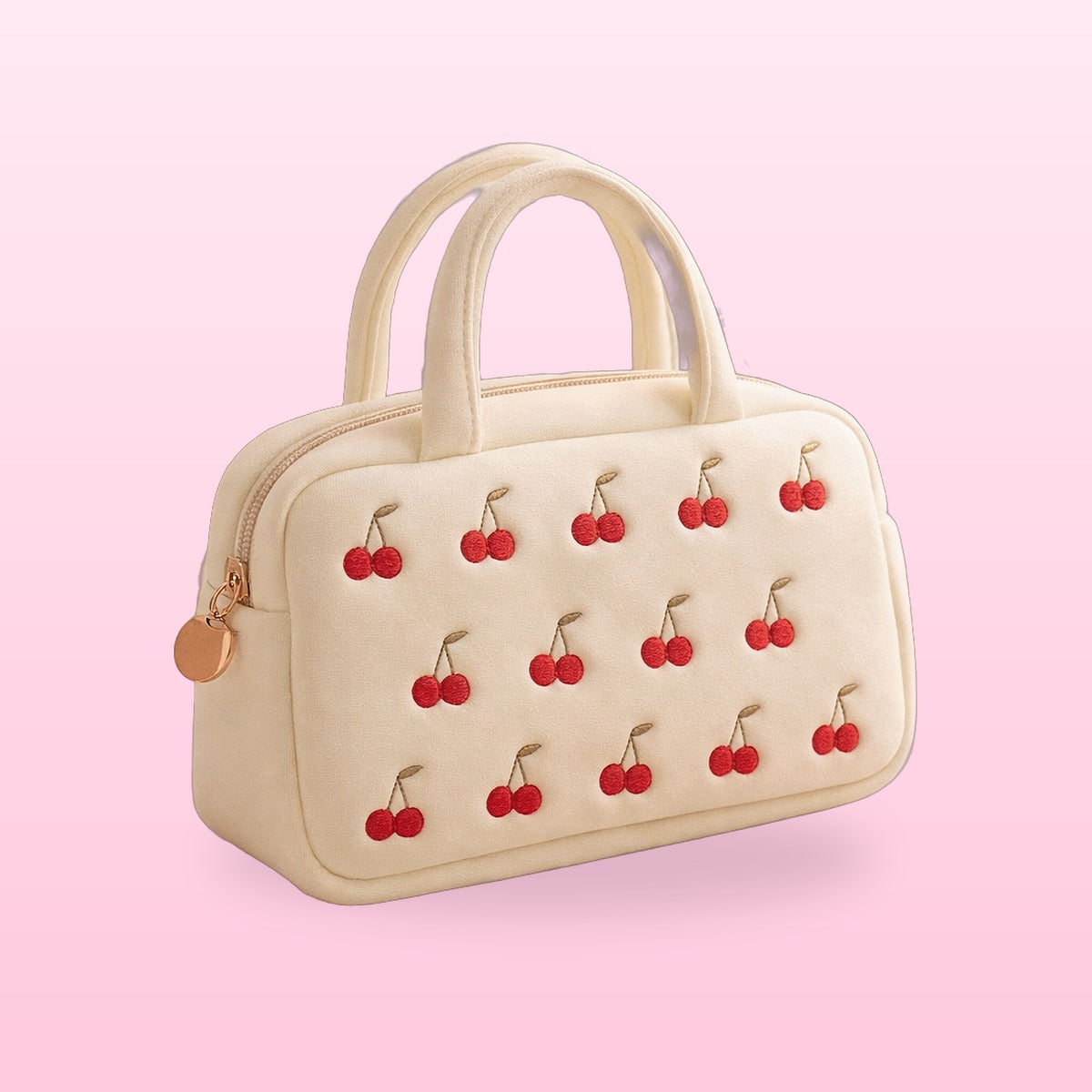Cream cherry embroidered vanity bag with twin handles on a pink background