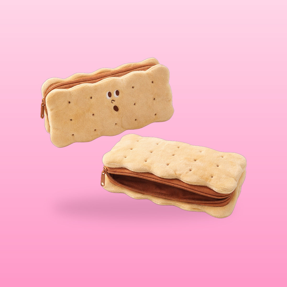 Plush sandwich cookie pencil case with a surprised embroidered face, one closed and one unzipped, on a pink background