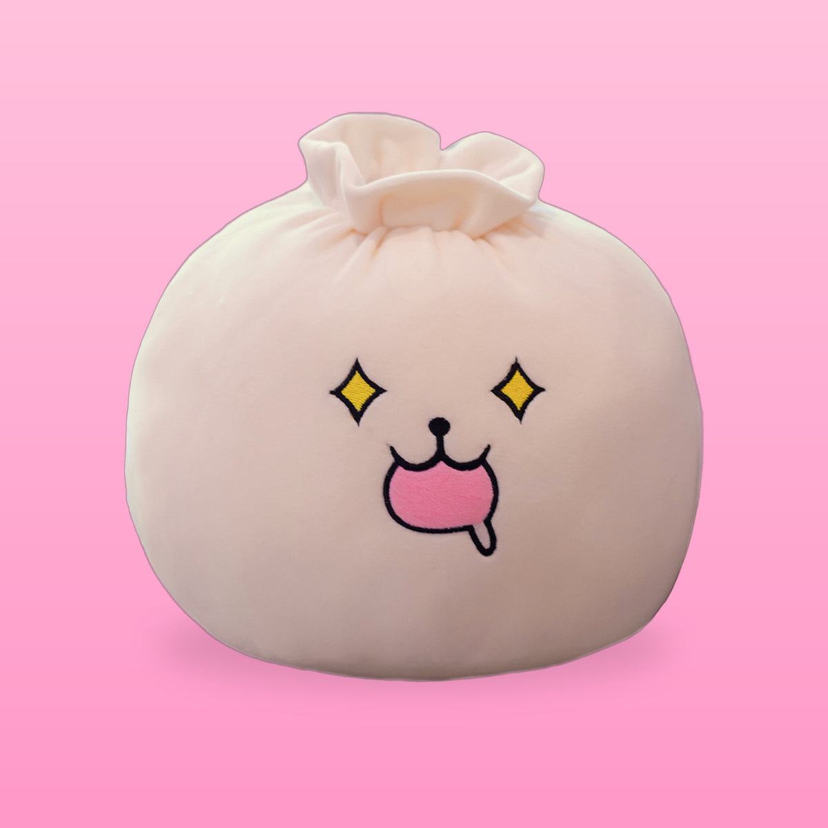 Cream bao bun plush pillow with sparkly eyes and a drooling pink mouth on a pink background