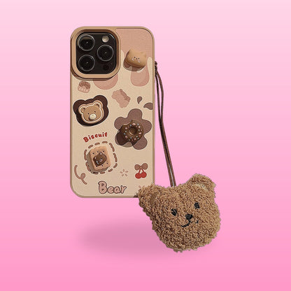 Cream iPhone case with 3D bear, donut and biscuit details and a fluffy plush bear charm on a pink background