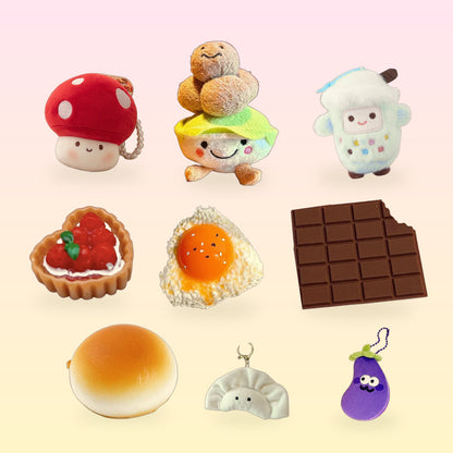 A mix of Scribble Snacks food-shaped plush charms, squishies and desk snacks on a pink and butter yellow background