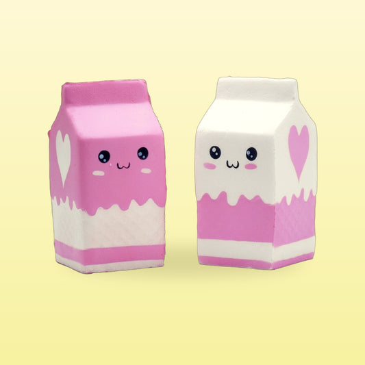 Strawberry pink and milky white milk carton squishies with smiley faces on a butter yellow background