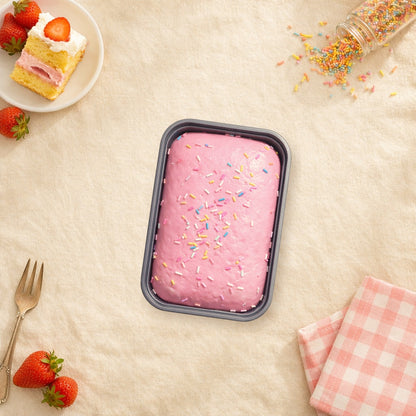 Strawberry sprinkle cake squishy on a cream tablecloth beside a slice of strawberry cake, rainbow sprinkles and fresh strawberries