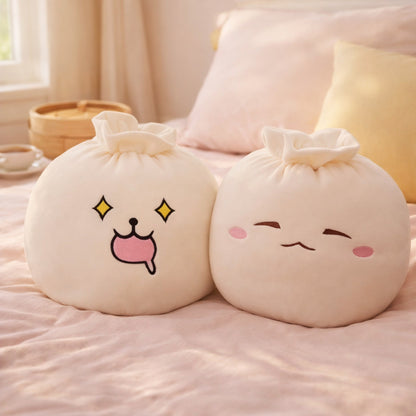 Two cream bao bun plush pillows on a pink bedspread beside a bamboo steamer basket and a cup of tea