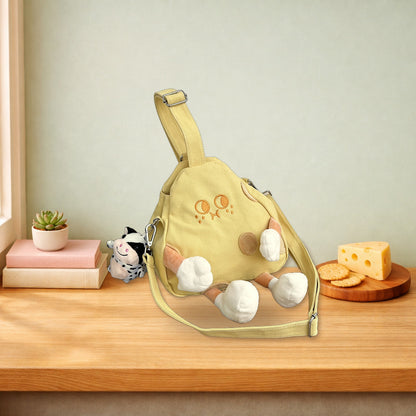 Cheese crossbody bag sitting on a wooden bench between a stack of books and a cheese board
