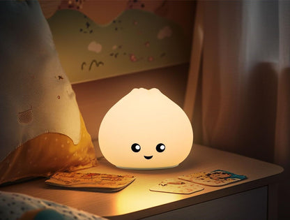 Bao bun night light glowing warm on a bedside table beside two picture cards