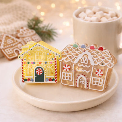 Gingerbread house claw clips on a cream dish beside a mug of hot chocolate with marshmallows