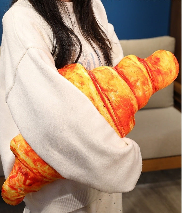 Person hugging the croissant pillow to show its cuddly size