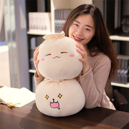 Smiling woman hugging two stacked bao bun plush pillows to show their cuddly size