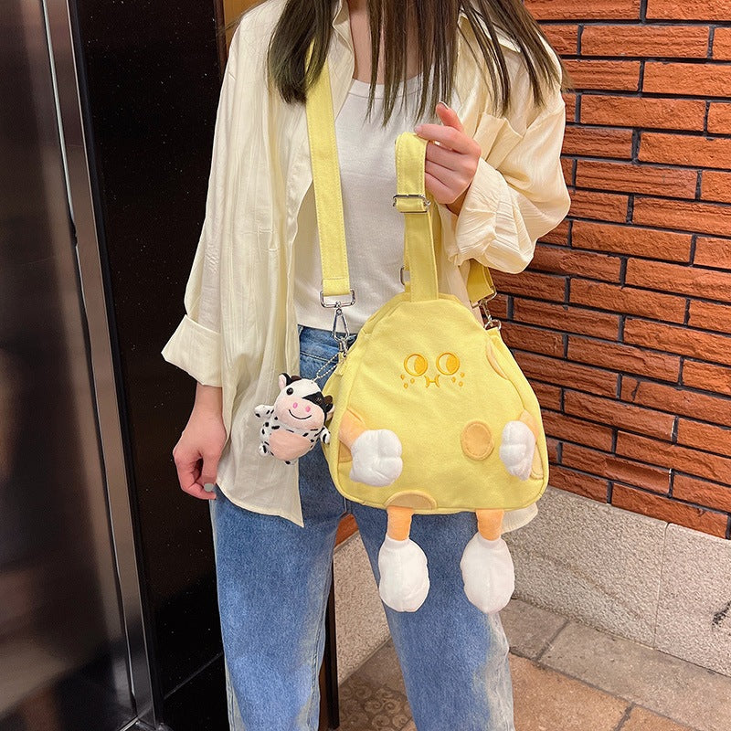 Person wearing the cheese crossbody bag across the body and holding its top handle