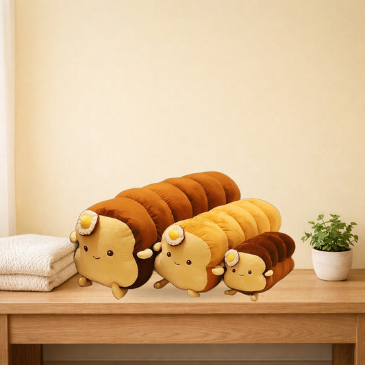 Long loaf and toast plush pillows with fried egg tops on an oak bench