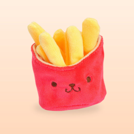 Red plush french fries keychain with an embroidered smiley face, on a soft peach background