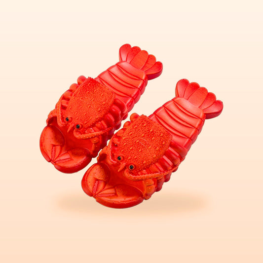 Pair of red lobster slippers with claw toes, on a peach background