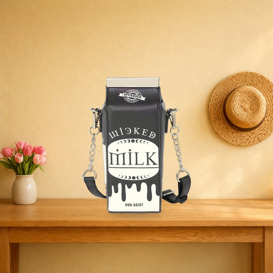 Black milk carton crossbody bag standing on a wooden console table