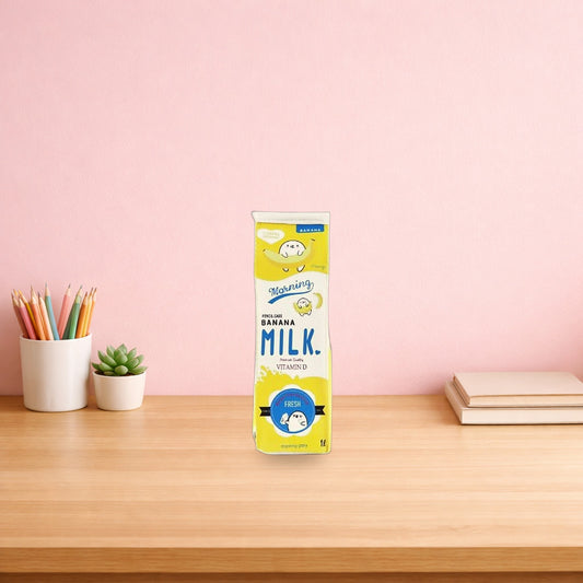 Yellow banana milk carton pencil case standing on a wooden desk